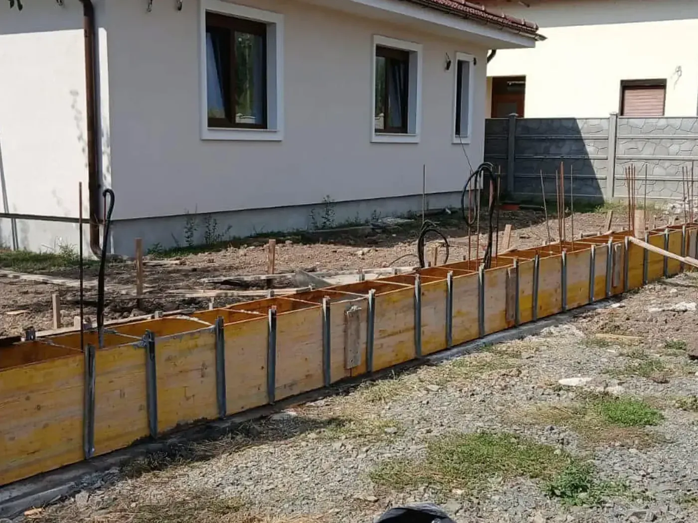Sávalap zsaluzata vasszereléssel lábazatos fa kerítés nyomvonalán